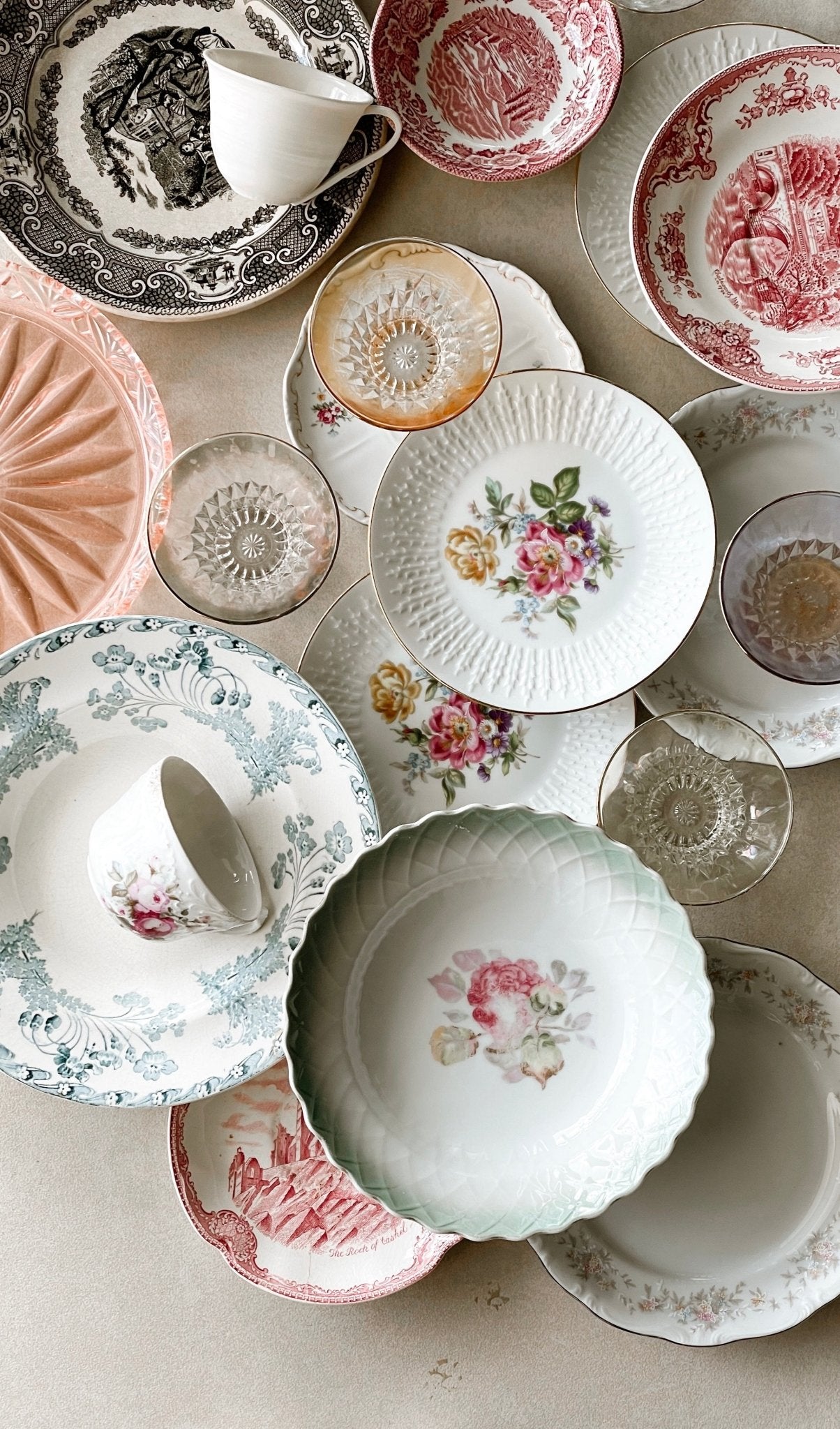 Fine art photography print of an overhead arrangement of vintage transferware china plates, teacups and bowls in pink red and gold, by Israeli artist Tamar Green